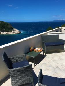a balcony with chairs and a table and the ocean at Apartments Kurelja in Lastovo