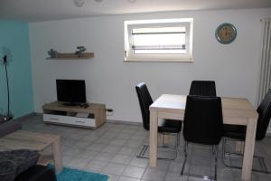 a living room with a table and chairs and a television at Ferienwohnung NeLe in Kappel-Grafenhausen