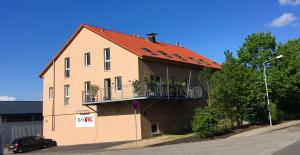 Nieder-Olmにある2nd Home Appartements Iのオレンジ色の屋根の建物(バルコニー付)