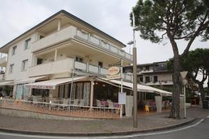 un bâtiment avec des tables et des chaises devant lui dans l'établissement Champagne Rooms, à Sirmione