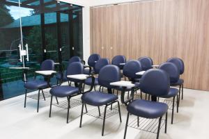 a group of chairs and tables in a room at CEIC Pousada e Eventos in Nova Trento