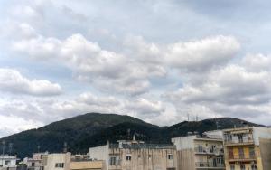 um grupo de edifícios em frente a uma montanha em LP Luxury Citycenter Studio em Xanthi