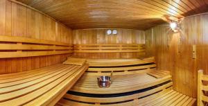 una gran sauna de madera con asientos de madera y 2 relojes en Hotel Vier Jahreszeiten en Berchtesgaden