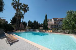 a large swimming pool with chairs and a building at Residence Oleandro in Pietra Ligure +82 photos