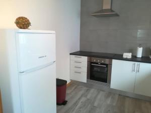 Una cocina con un refrigerador blanco y una estufa. en Casa das Sereias, en Rabo de Peixe