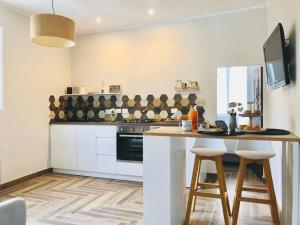 a kitchen with white cabinets and a counter with stools at Sciri Suite #2 in Perugia