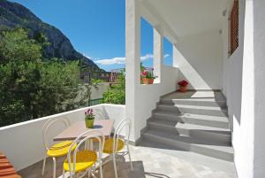 d'un balcon avec une table, des chaises et des escaliers. dans l'établissement Apartmani Maslina, à Gradac
