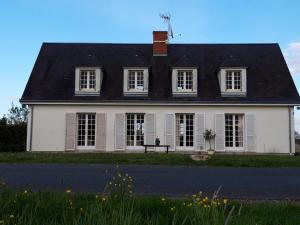a white house with a black roof at Terrasses de Loire 1er étage in Saint-Clément