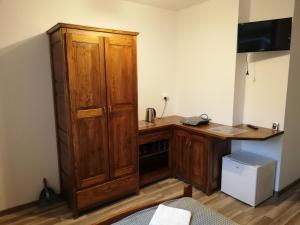 Pokój z biurkiem i dużą drewnianą szafką w obiekcie Sloneczna Kwatera w Cisnej