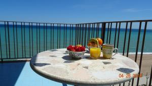 una mesa con un bol de fruta y un vaso de zumo de naranja en Apartament La Vista Bonica en Blanes