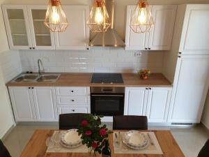 a kitchen with white cabinets and a table with plates on it at Apartment Kristina in Vlašići