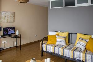 sala de estar con sofá y almohadas amarillas en Acogedor apartamento con vista al mar, en Tacoronte