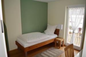 a small bed in a room with a window at Weingut Lehnert-Veit Gutshotel in Piesport