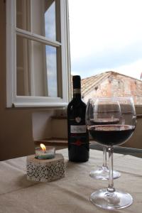 una bottiglia di vino seduta accanto a un bicchiere di vino di Delizioso Appartamento Centro Storico Lucca Comics a Lucca