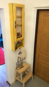 un armadio giallo e uno sgabello accanto a una porta di Apartmán Zlaté časy na Trojici a Banská Štiavnica