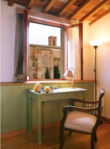 einen Tisch und einen Stuhl in einem Zimmer mit Fenster in der Unterkunft Casacenti B&B in Siena