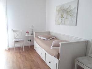 ローマにあるL'Incantevole Aventinoの白いベッドルーム(花の絵が飾られたベッド付)