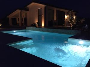 - une piscine la nuit avec une maison en arrière-plan dans l'établissement Ranieri Events and B&B, à Casacanditella