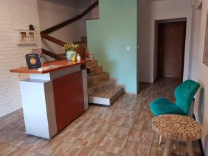 a lobby with a staircase and a table and green chairs at B&B Villa Varmia in Frombork