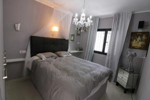 Un dormitorio con una cama grande y una lámpara de araña. en Atlantic Ocean View, en Puerto del Carmen