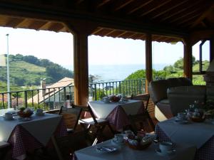 a restaurant with two tables and a view of the ocean at Pensión Bella Vista in Cóbreces