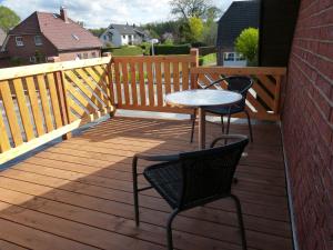 2 sillas y una mesa en una terraza de madera en Ferienwohnung Ochtmissen, en Lüneburg