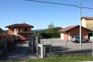 una casa con una recinzione e una macchina nel vialetto di Casa Ilaria ad Armeno