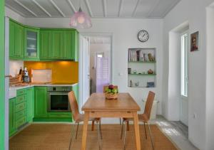 una cucina con armadi verdi e tavolo in legno di Villa Rosa-Maria a Città di Tinos