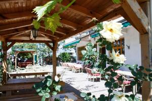 un patio con tavoli, sedie e fiori bianchi di Apartmani S.KILAĆI a Blagaj