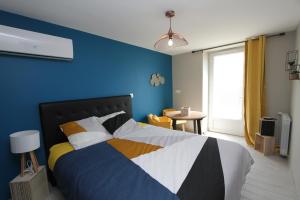 a bedroom with a bed with a blue wall at Naphéo in Tonnay-Charente