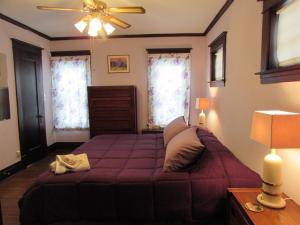 um quarto com uma cama roxa e uma ventoinha de tecto em Whirlpool Cottage em Niagara Falls