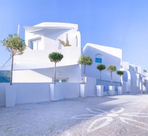 a white building with trees on the side of it at Aegean of Amorgos in Katapola