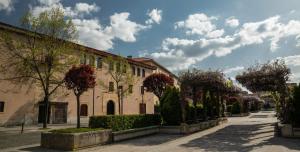 a building with trees in front of a street at Hotel Melibea by gaiarooms in Salamanca