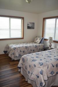 a bedroom with two beds and two windows at Coquille Point Condo in Bandon