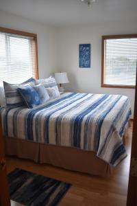 um quarto com uma cama com um edredão azul e branco em Coquille Point Condo em Bandon