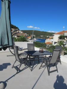 a table and two chairs and an umbrella on a patio at House Olivia in Pučišća