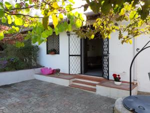 une porte d'entrée d'une maison blanche ornée de fleurs dans l'établissement VILLETTA ROSA IV strada Fegotto, à Floridia