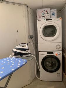 a washer and a washing machine in a room at Les pieds dans l'eau accès direct à la plage ! in Granville