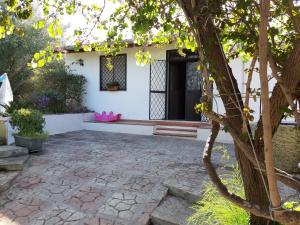 a house with a patio and a tree at VILLETTA ROSA IV strada Fegotto in Floridia