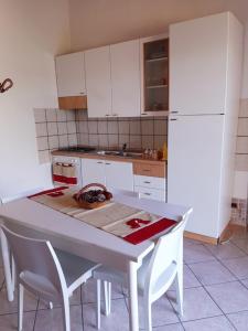 a kitchen with a table and a white refrigerator at VILLETTA ROSA IV strada Fegotto in Floridia
