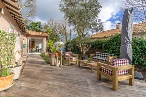 a patio with three benches and a umbrella at Maison douillette à 700m des plages in Saint-Brevin-les-Pins