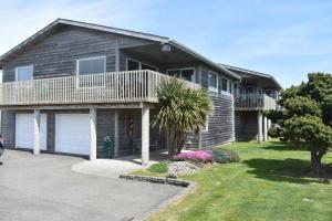 a house with a porch and a garage at Coquille Point Condo in Bandon