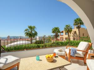 a balcony with a table and chairs and palm trees at Ses Vistes in Nuestra Señora de Jesus