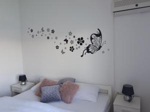 Dormitorio con cama con pared de mariposa en Apartments Sara, en Tisno