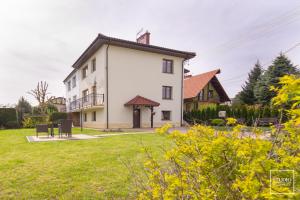 a large white building with a grass yard at VIKTORIA Wadowice in Wadowice