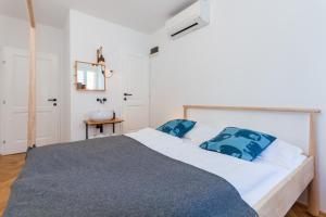 a bedroom with a white bed with blue pillows at Little Tower With Terrace by Locap Group in Piran