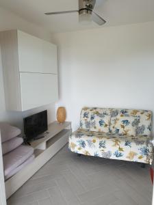 un soggiorno con divano e TV di La casa del Tramonto a Praia a Mare