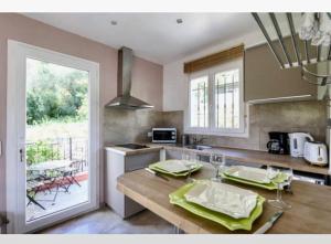 a kitchen with a table with green napkins on it at STUDIO pied village EZE - dans VILLA - Parking Gratuit in Éze