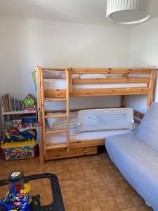サン・シプリアン・プラージュにあるVilla rapatelのベッドルーム1室(二段ベッド1組、ベッド1台、テーブル付)