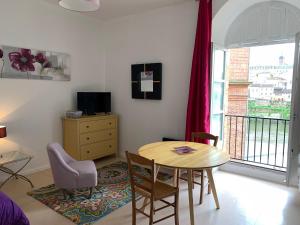 a living room with a table and chairs and a window at Studio coeur historique Albigeois in Albi